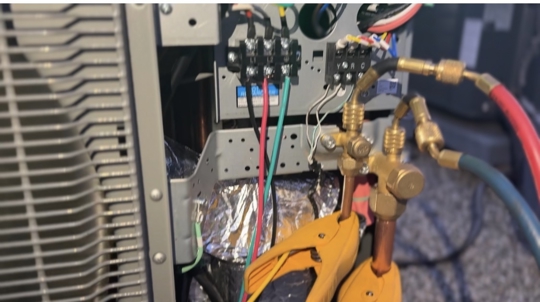 hvac technician diagnosing air conditioner blowing warm air in Vista CA