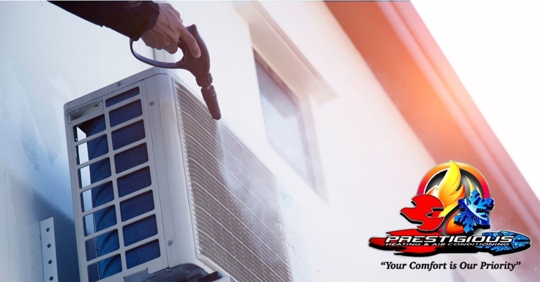 Technician cleaning outdoor HVAC