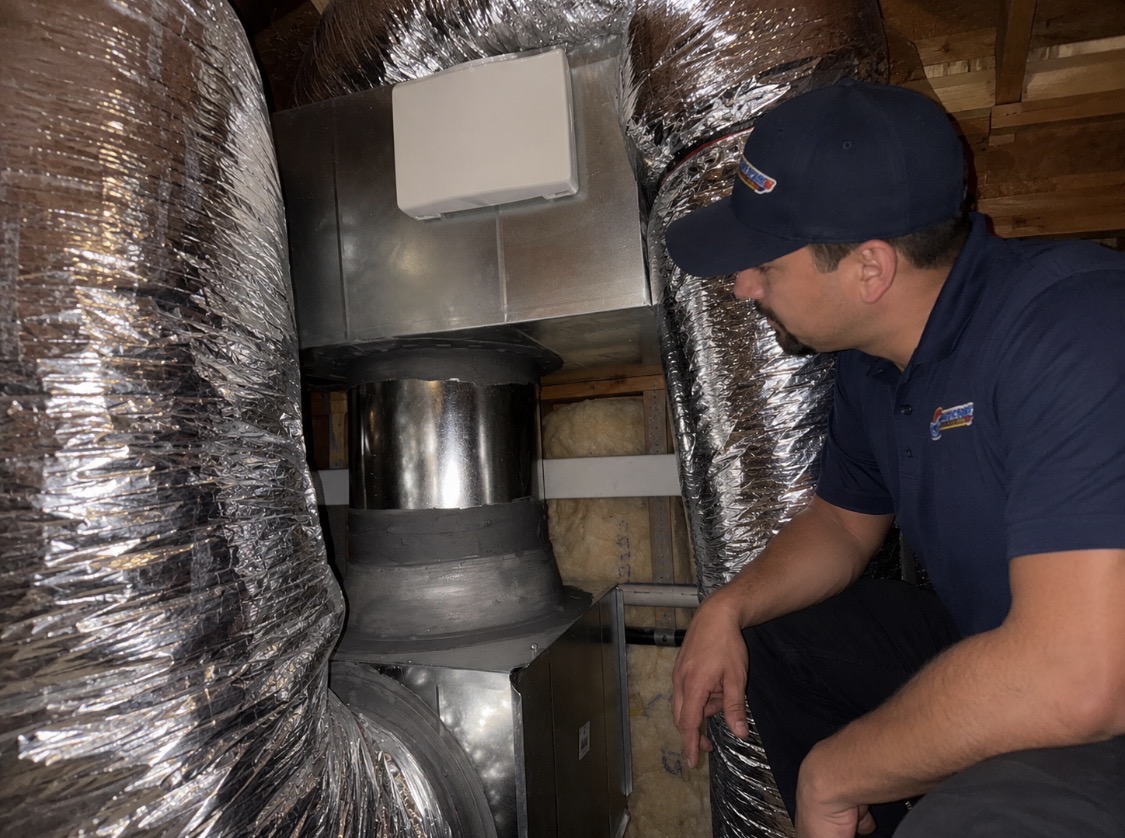 Custom HVAC duct transition installation showing sealed sheet metal workmanship in a Carlsbad CA attic